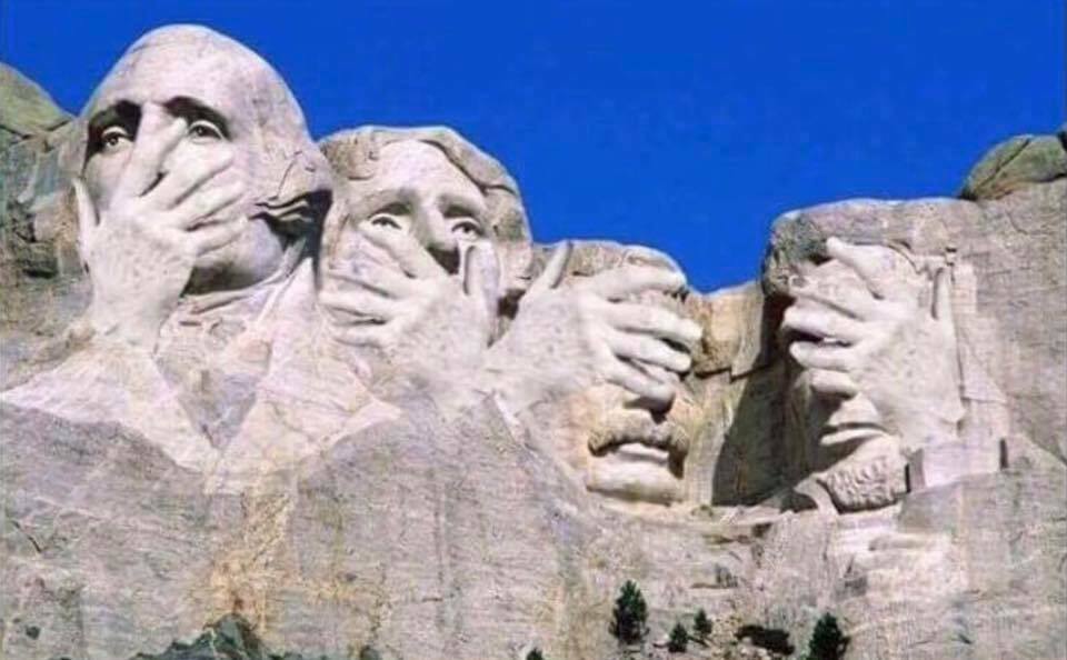 Photograph of Mount Rushmore with hands over faces