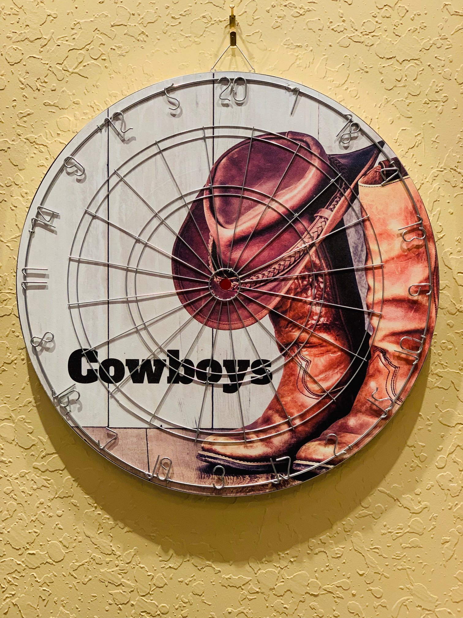 Photograph of dart board with cowboy boot hat